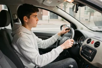 Jeune conducteur adolescent au volant d'une voiture sans permis en milieu urbain